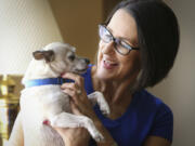 Michele Longabaugh holds her Chihuahua, Smokey. Longabaugh acquired Smokey from the Kansas Humane Society just an hour or so after she learned she had cancer. She is currently cancer-free and says Smokey helped make the chemo, radiation and surgery bearable. &quot;Through long nights of misery and pain, he was there for me,&quot; she said.