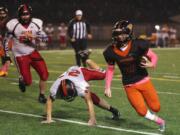 Washougal Panther Kade Coons runs with the ball as he is pursued by RA Long Lumberjacks Parker reeves (C) and Keoni Mawae (L)  at Washougal Friday October 21, 2016.