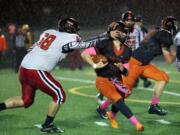 RA Long Lumberjack Keoni Mawae grabs the face-mask of Washougal Panther Ryan Stevens at a game in Washougal Friday October 21, 2016.