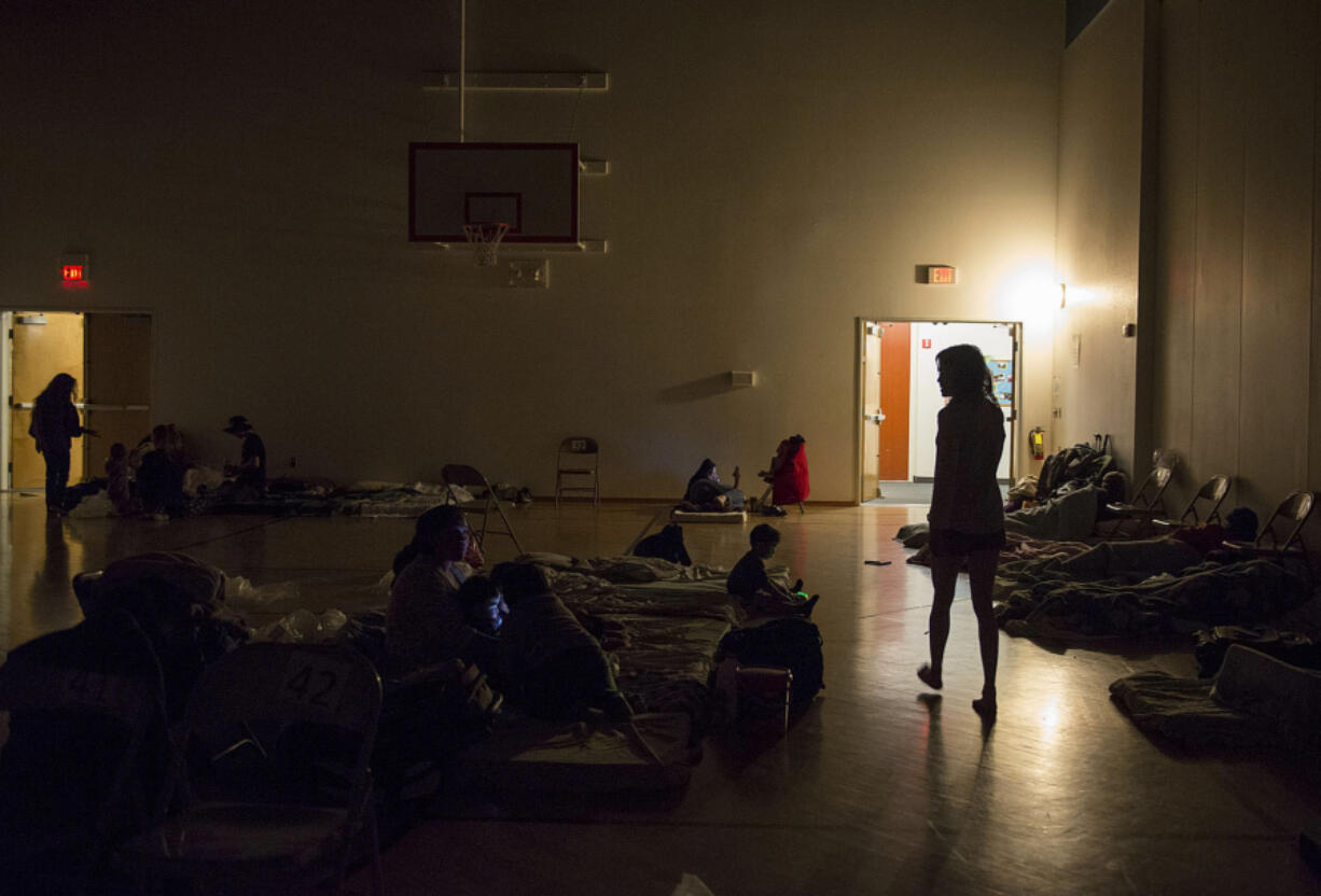 Donna Pinaula, right, searches for her son, Johnny Pinaula, 7, after volunteers at the Winter Hospitality Overflow shelter turn out the lights so people can sleep in 2015 at St. Andrew Lutheran Church.