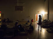 Donna Pinaula, right, searches for her son, Johnny Pinaula, 7, after volunteers at the Winter Hospitality Overflow shelter turn out the lights so people can sleep in 2015 at St. Andrew Lutheran Church.