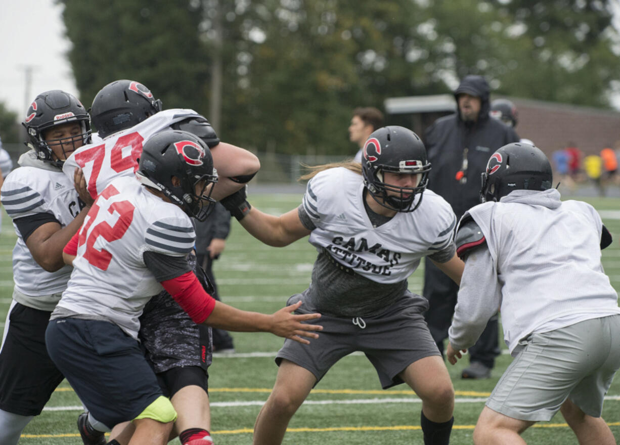 Camas High School's Dakota Napierkowski, center, takes on teammates at the team's practice field Wednesday afternoon, Oct. 5, 2016.