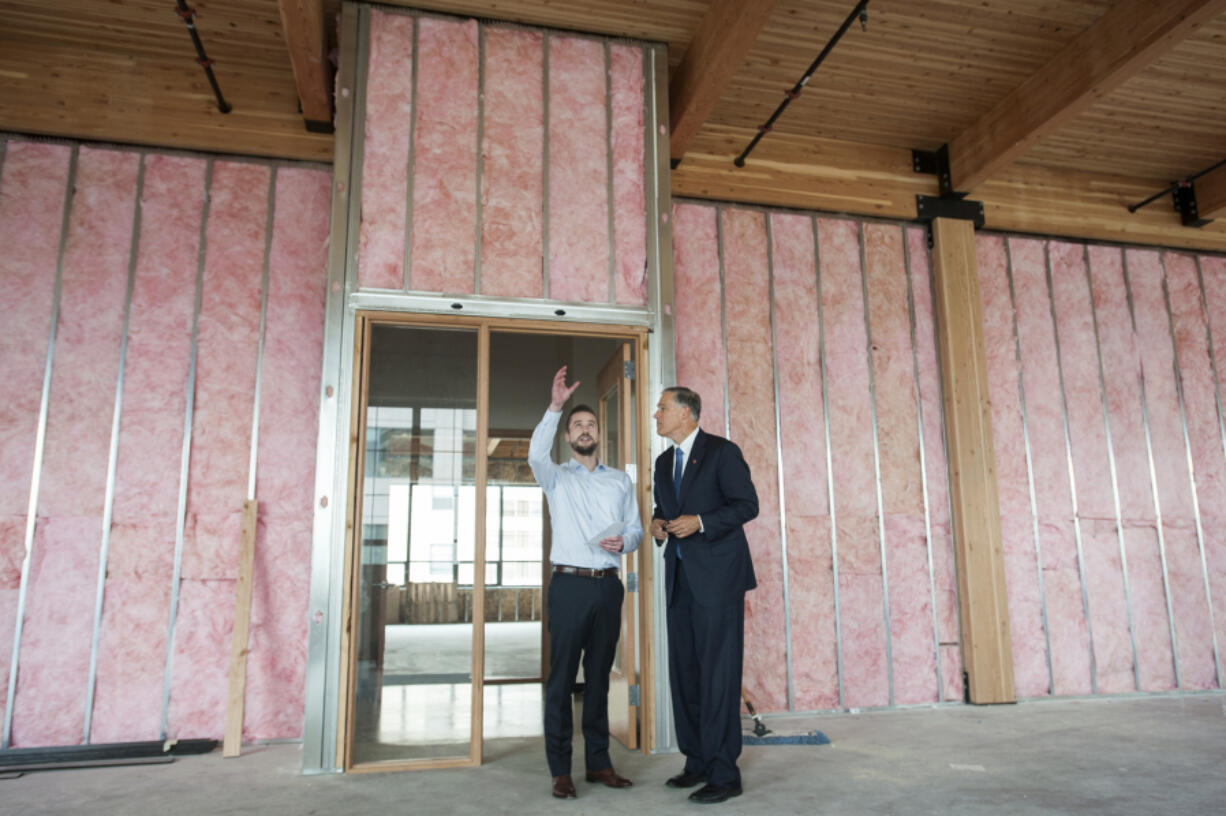 Sean McClain, founder and CEO of AbSci, left, guides Gov. Jay Inslee through the biotechnology company&#039;s new Vancouver headquarters on Monday. AbSci is moving its headquarters from Portland to the new Hudson Building in downtown Vancouver.