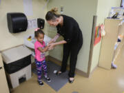 Ashley Horn helps her daughter, Icess, 4, dry her hands at Hough Early Learning Center in Vancouver on Thursday. Horn, a single mother, credits the Hough Early Learning Center for helping her find a job, get her GED and enroll in cosmetology school.