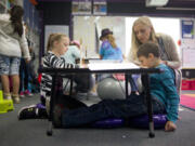 Megan Lascik helps Trevor Maxwell, 8, on an assignment Tuesday while Trevor sits on core discs, one of the multiple flexible seating options in Lascik&#039;s third-grade class at Woodland Intermediate School.