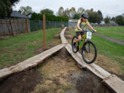 Battle Ground resident Grady McHenry, 11, rides to the end of an elevated plank feature at the new Washougal Bike Park Skills Course in Hamllik Park on Saturday.