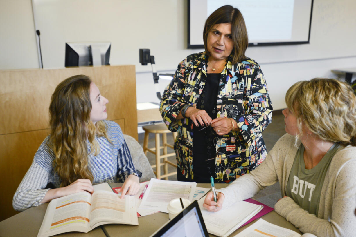 Professor Gisela Ernst-Slavit, center, helps education students during an Introduction to English-Language Learners course Monday at Washington State University Vancouver. WSU received a $2.2 million grant to put more than 50 bilingual teachers in classrooms in Vancouver and the Tri-Cities.