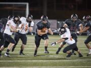 Camas Jack Colletto (9) pushes past Battle Ground players in the first quarter at Doc Harris Stadium in Camas, Friday September 30, 2016.