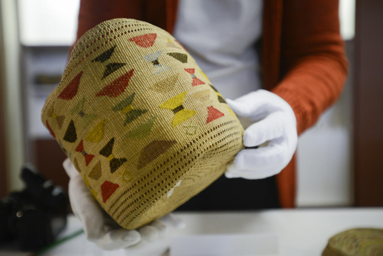 Anderson inspects an Aleut basket Wednesday before packing it up in preparation for a remodeling project at the Clark County Historical Museum.