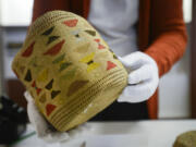 Anderson inspects an Aleut basket Wednesday before packing it up in preparation for a remodeling project at the Clark County Historical Museum.