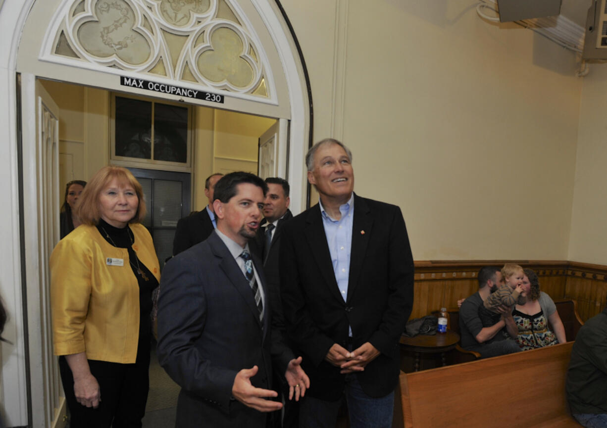 Washington Gov. Jay Inslee, right, admires the vaulted ceilings as he talks with Michael True of the Fort Vancouver National Trust in the chapel of the Providence Academy building.