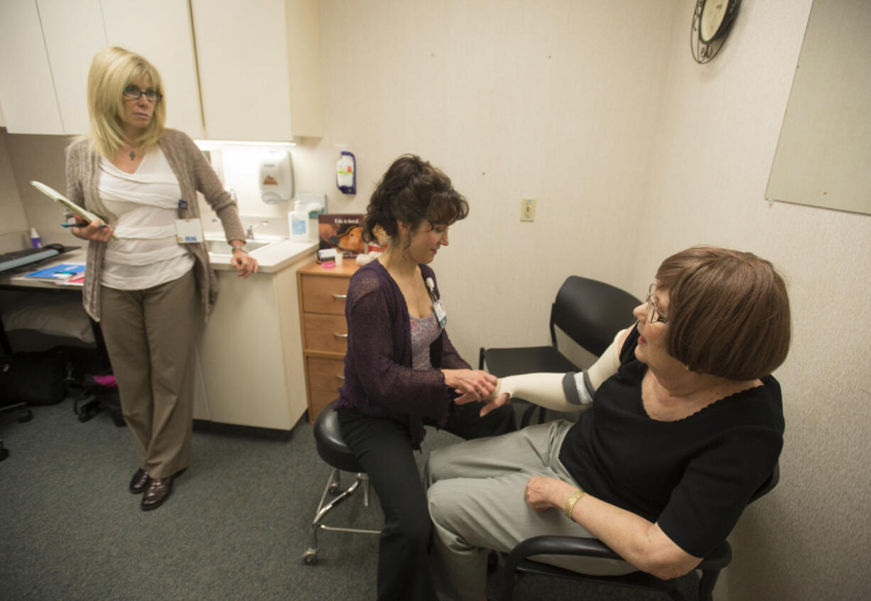 Registered nurse Gina Richardson, from left, and physical therapist Joyce Masters talk with patient Nancy Lindley of Vancouver during an appointment Sept. 7 at PeaceHealth Southwest Medical Center. Lindley, 75, was diagnosed in January with advanced lymphedema that required several weeks of compression wrapping to reduce swelling.