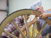 John Keller, 17, left, and historical preservation specialist Fred Munhoven check out the fit of a component known as a felloe in a cannon wheel last week.