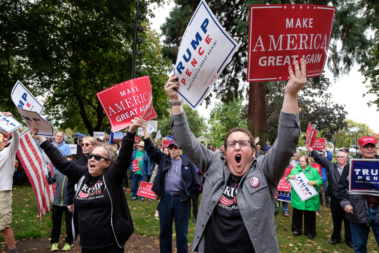 Jonathan Lundess, right, and his mother, Laurie Lundess, both of Vancouver, hold signs and cheer in support of Donald Trump at a rally Sunday in Esther Short Park.