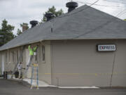 Mike Roby of Saxon Enterprises applies a fresh coat of paint Monday afternoon to the building known as a shoppette, as well as an express, at Fort Vancouver National Historic Site.