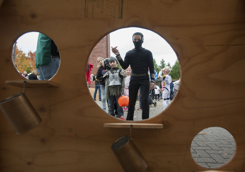 Benjamin Houston, 10, of Washougal, center, is dressed as a ninja/assassin while taking aim at the bean bag toss during the Downtown Washougal Harvest Pumpkin Festival on Wednesday afternoon, Oct. 19, 2016.