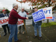 Republican gubernatorial candidate Bill Bryant, left, shakes hands with supporter Kile McCarty in Vancouver on Monday. Bryant is traveling around the state in an effort to encourage voters to be sure to cast their ballot.