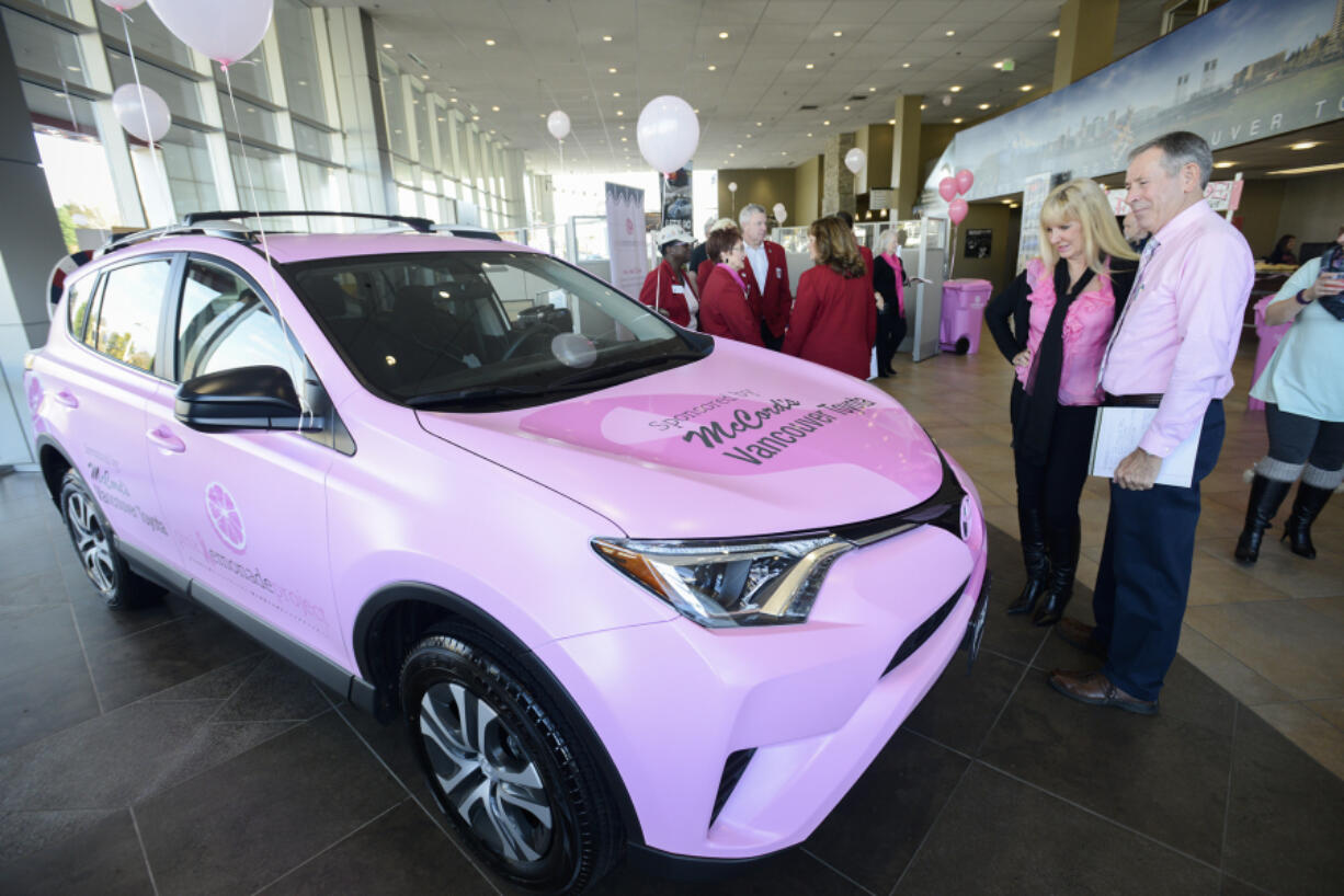 Don Stose, the legislative liaison for the Pink Lemonade Project, right, and Jeanne Firstenburg, former president of the Pink Lemonade Project, admire a pink Toyota RAV4 on Friday at McCord&#039;s Vancouver Toyota. McCord&#039;s donated the SUV to the Vancouver nonprofit. Markon Brand Design wrapped the vehicle in pink and the nonprofit&#039;s logos.