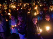 People gather to remember Elizabeth Smith, 11, during a candlelight vigil Sunday night at Daybreak Middle School in Battle Ground. She was killed after being struck by a minivan last week while waiting for her school bus.