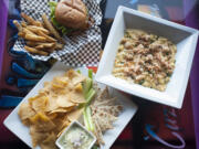 The spinach artichoke dip, bottom, lobster macaroni and cheese, right, and the barbecue chicken sandwich are served at Hooligan&#039;s Sports Bar and Grill in Vancouver.