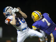 Ridgefield&#039;s Conner Bell (88) catches a pass in front of Columbia River defender Nathan Kunz (7) in the third quarter at Kiggins Bowl on Thursday night, Oct. 27, 2016.