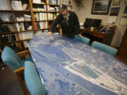 Chris Lapp of the U.S. Fish and Wildlife Service, the project leader at the Ridgefield National Wildlife Refuge, spreads out a big map in his office that shows the Port of Ridgefield (at bottom) and the Carty Unit of the Refuge (above). The Port has built trails across its property; the Refuge will build new ones to meet them. The result will be a miles-long seasonal walking loop.