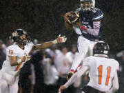 Battle Ground's Tommy Renfroe (13) and Izak Brundage (11) defend against Skyview's Jeremiah Wright (21) as he hauls in a pass in the second quarter at Kiggins Bowl on Thursday night, Oct. 13, 2016.