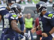 Seattle Seahawks quarterback Russell Wilson, right, celebrates with teammate C.J. Spiller, left, after they connected for a touchdown during the first half of an NFL football game against the New York Jets, Sunday, Oct. 2, 2016, in East Rutherford, N.J.