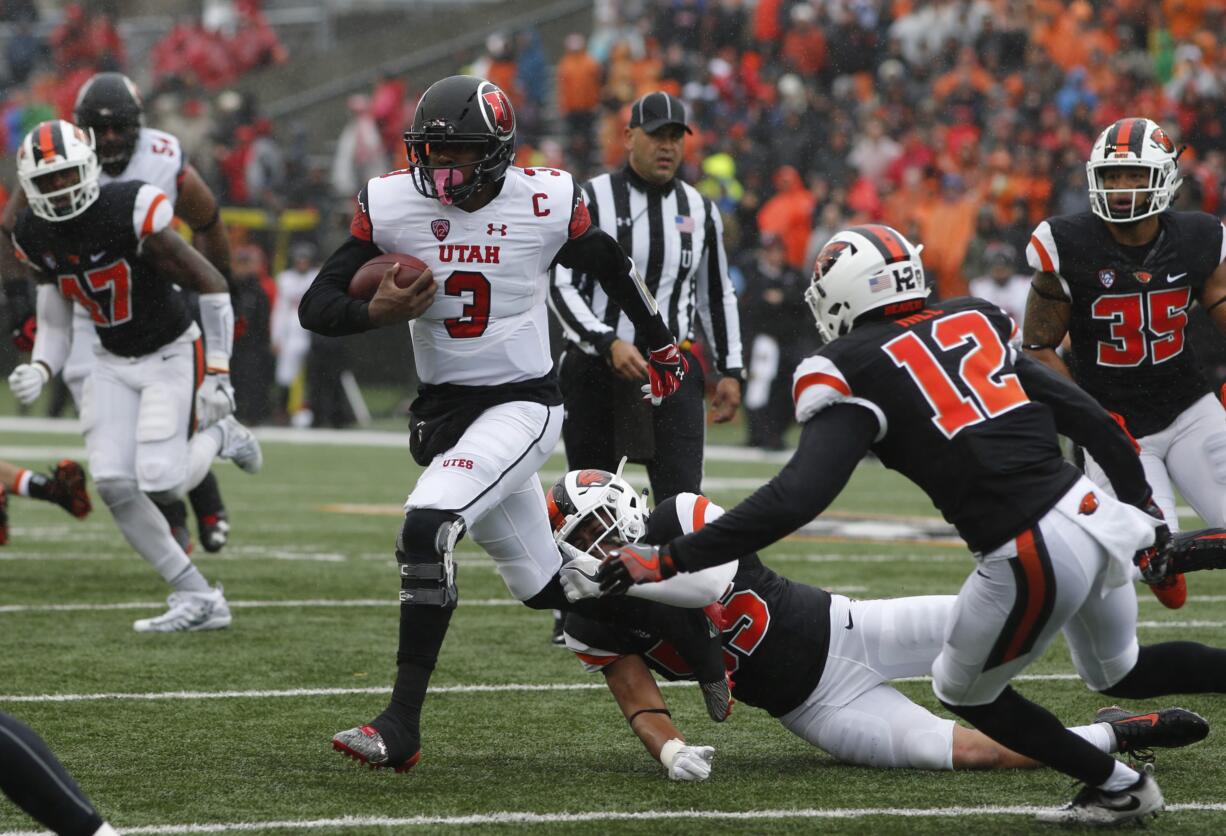 Utah quarterback Troy Williams (3) tries to pull away from Oregon State's Manase Hungalu, bottom, and Kendall Hill (12) in the first half of an NCAA college football game in Corvallis, Ore., on Saturday, Oct. 15, 2016. (AP Photo/Timothy J.