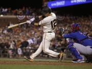 San Francisco Giants' Joe Panik (12) hits a double to score Brandon Crawford in front of Chicago Cubs catcher David Ross during the thirteenth inning of Game 3 of baseball's National League Division Series in San Francisco, Monday, Oct. 10, 2016. The Giants won 6-5 in 13 innings.