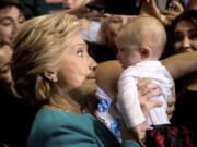 Democratic presidential candidate Hillary Clinton holds up a baby as she greets members of the audience after speaking at a rally at Palm Beach State College in Lake Worth, Fla., on Wednesday.