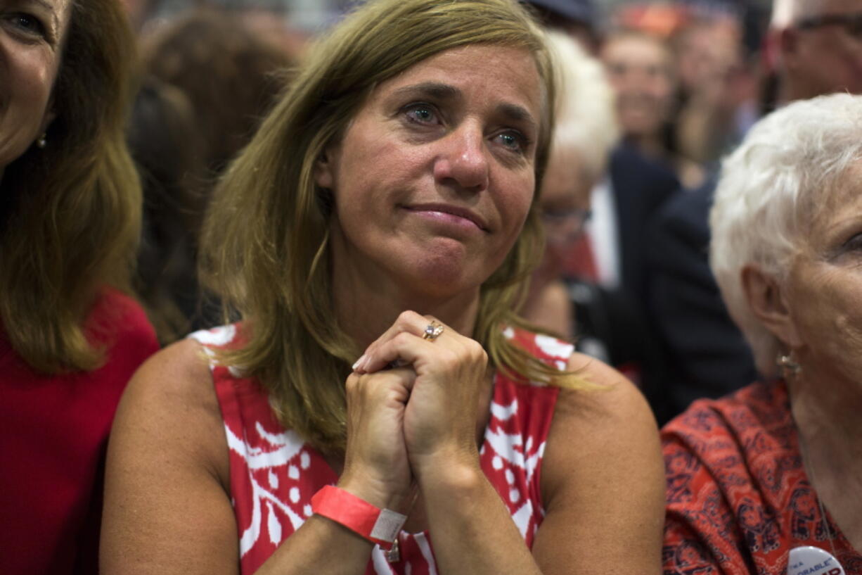 Rochelle Pasquariello of Leighton, Pa., watches as Republican presidential candidate Donald Trump speaks at a campaign rally Friday in Newtown, Pa.