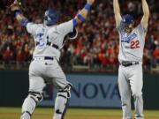 Los Angeles Dodgers pitcher Clayton Kershaw (22) and catcher Carlos Ruiz celebrate after Washington Nationals' Wilmer Difo struck out to end Game 5 of baseball's National League Division Series at Nationals Park early Friday, Oct. 14, 2016, in Washington. The Dodgers won 4-3.