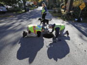 Scott Reynolds of Environmental Canine Systems, left, and Fred Dillon, the stormwater program coordinator for the city of South Portland, Maine, inspect a stormwater drain pipe in South Portland. Remi, a dog trained to sniff out sources of water pollution, with handler Karen Reynolds, rear, detected human fecal bacteria in the pipe. Many communities across the country are saving time and money by using dogs to find sources of pollution instead of gathering samples to be sent to laboratories for testing. (AP Photo/Robert F.