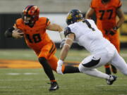 Oregon State quarterback Darell Garretson (10) tries the avoid California&#039;s Devonte Downs (1) during the first half of an NCAA college football game in Corvallis, Ore., on Saturday, Oct. 8, 2016. (AP Photo/Timothy J.