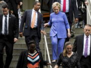 Democratic presidential candidate Hillary Clinton, right, speaks with Traveling Political Advisor Darren Peters, center left, as she leaves an early voting brunch Sunday at Fado Irish Pub in Miami.