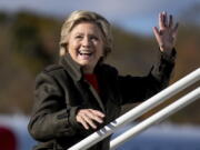 Democratic presidential candidate Hillary Clinton waves to members of the media as she boards her campaign plane at Westchester County Airport in White Plains, N.Y., on Monday to travel to Cleveland for a rally.