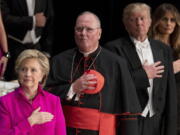 From left, Democratic presidential candidate Hillary Clinton, Cardinal Timothy Dolan, Archbishop of New York; Republican presidential candidate Donald Trump, and his wife Melania Trump, stand for the Star Spangled Banner at the 71st annual Alfred E. Smith Memorial Foundation Dinner, a charity gala organized by the Archdiocese of New York on Thursday at the Waldorf Astoria hotel in New York.