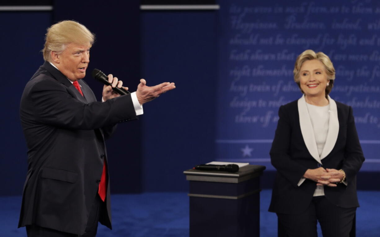 Republican presidential nominee Donald Trump speaks with Democratic presidential nominee Hillary Clinton during the second presidential debate at Washington University in St. Louis on Sunday.