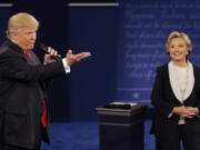 Republican presidential nominee Donald Trump speaks with Democratic presidential nominee Hillary Clinton during the second presidential debate at Washington University in St. Louis on Sunday.