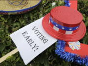 An early voting sign is placed on the grass at an early voting celebration outside of Jackson Memorial Hospital, on the first day of early voting in Miami. The millions of votes that have been cast already in the U.S. presidential election point to an advantage for Hillary Clinton in critical battleground states, as well as signs of strength in traditionally Republican territory.