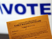 An early ballot envelope is held at town hall in North Andover, Mass.