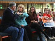 FILE - In this Oct. 22, 2016 file photo, former Arizona congresswoman Gabby Giffords, second from left, and Gov. Jay Inslee, left, fist bump at a rally in support of Initiative 1491 in Seattle. The initiative, which will be on the ballot in the November election, would would allow family members and law enforcement officials to petition a judge to temporarily suspend a person&#039;s access to firearms if the court finds that he is a threat to himself or others.