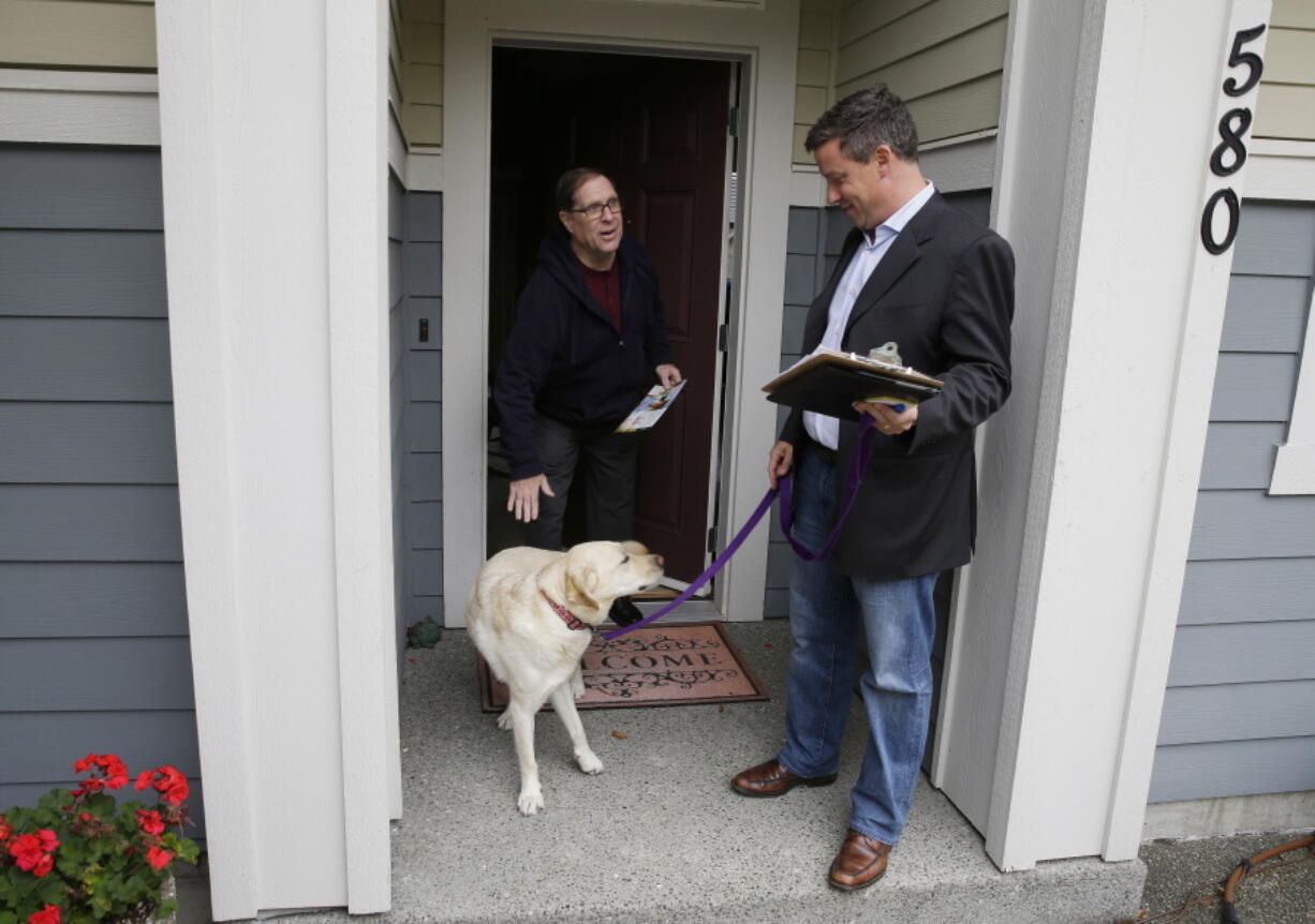 Sen. Mark Mullet, D-Issaquah, right, talks to a voter as he rings doorbells with his dog Arthur in Issaquah, Wash. Mullet is being challenged for his seat in the state legislature by State Rep. Chad Magendanz, R-Issaquah. (AP Photo/Ted S.