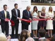 Republican presidential candidate Donald Trump, together with his family, from left, Donald Trump Jr., Eric Trump, Trump, Melania Trump, Tiffany Trump and Ivanka Trump, cut the ribbon during the grand opening of Trump International Hotel in Washington, Wednesday, Oct. 26, 2016. Donald Trump and his children hosted an official ribbon cutting ceremony and press conference to celebrate the grand opening of his new hotel.