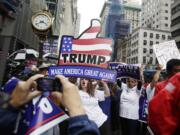 Supporters of Republican presidential nominee Donald Trump gather at Trump Tower Saturday, Oct. 8, 2016, in New York. Trump insisted Saturday, Oct. 8, 2016, he would "never" abandon his White House bid, facing an intensifying backlash from Republican leaders across the nation who called on him to quit the race following the release of his sexually charged comments caught on tape.