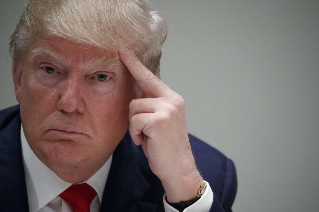 Republican presidential candidate Donald Trump listens to a speaker during a meeting with Cuban supporters at Trump National Doral on Tuesday in Miami.