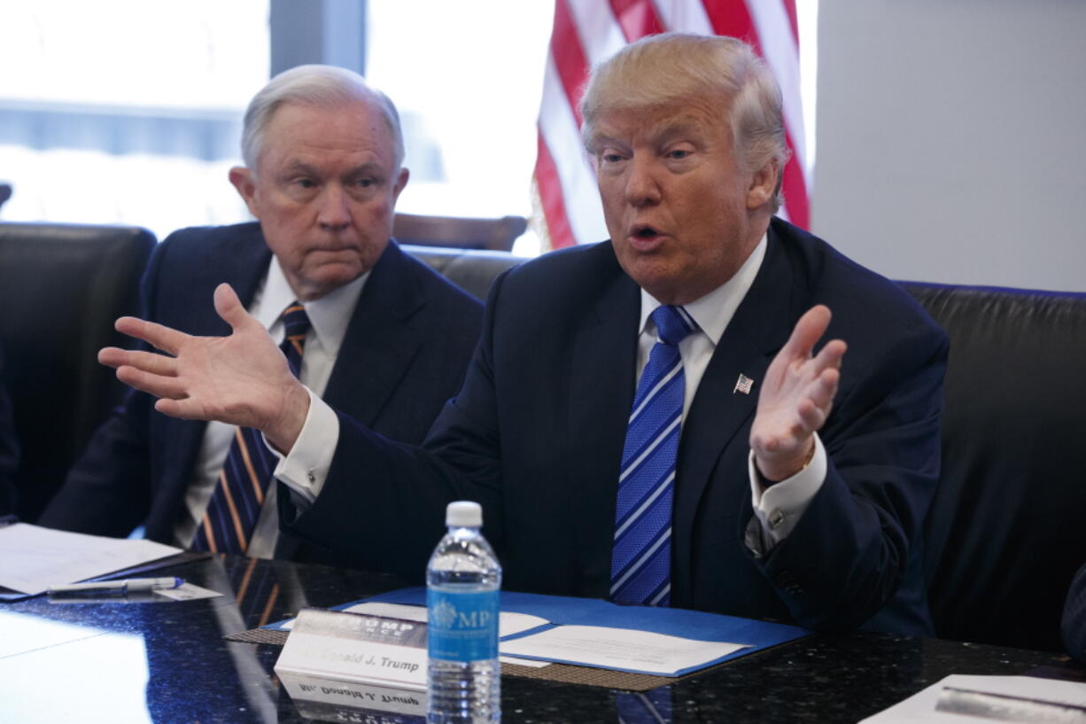 Sen. Jeff Sessions, R-Ala., left, looks on Friday as Republican presidential candidate Donald Trump speaks during a national security meeting with advisers at Trump Tower in New York.