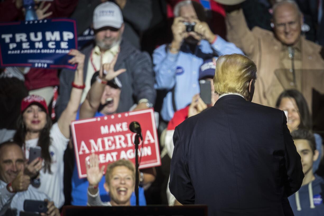 Republican presidential candidate Donald Trump, right, turns from the podium after speaking during a campaign rally, Thursday, Oct. 13, 2016, in Cincinnati.