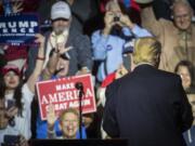 Republican presidential candidate Donald Trump, right, turns from the podium after speaking during a campaign rally, Thursday, Oct. 13, 2016, in Cincinnati.